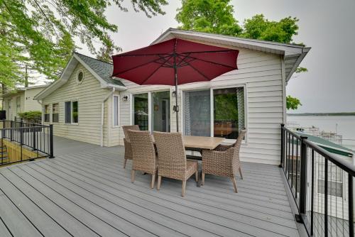 a deck with a table and chairs and an umbrella at Cayuga Lake Retreat in Seneca Falls with Dock! in Seneca Falls