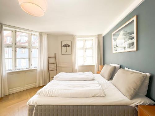 Cama grande en habitación con 2 ventanas en Large Flat with 4 Bedrooms in Copenhagen en Copenhague