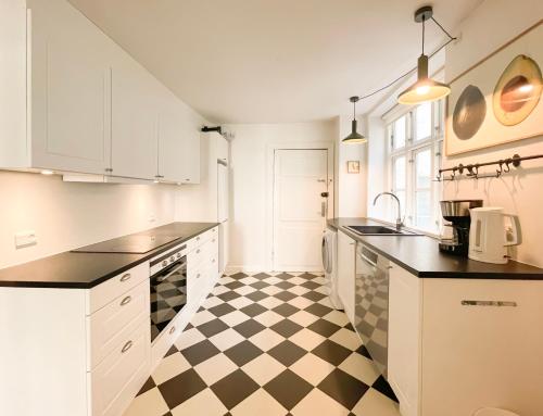 una cocina con suelo a cuadros en blanco y negro en Large Flat with 4 Bedrooms in Copenhagen en Copenhague