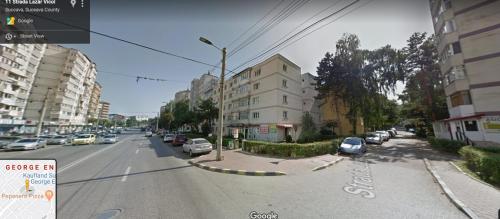 vistas a una calle de la ciudad con coches aparcados en Eva apartment, en Suceava