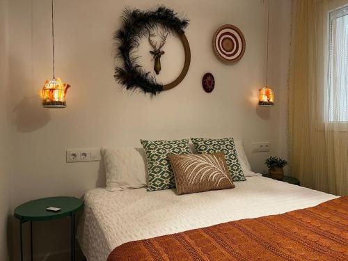 a bedroom with a bed with a wreath on the wall at Vivienda Oasis Feria in Albacete