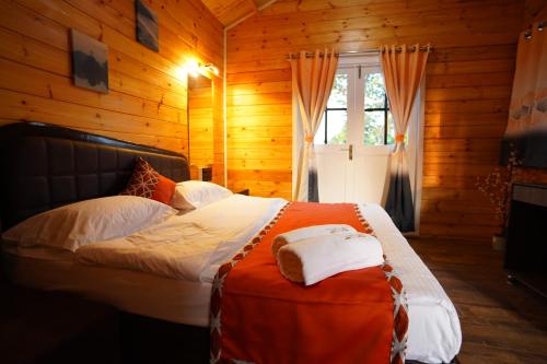 a bedroom with a bed in a wooden cabin at Coastal Bay Inn By Gemstone Hospitality in Alibaug
