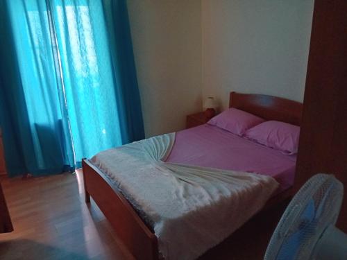 a bedroom with a bed with pink sheets and a window at T3 N16 Ref 008 in Tavira