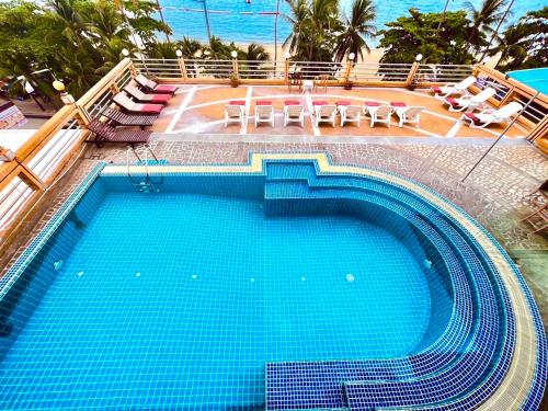 a large swimming pool with blue water in a resort at AA Hotel Pattaya in Pattaya Central