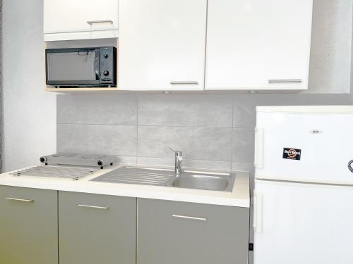 a kitchen with a sink and a microwave at les Jardiniers in Strasbourg