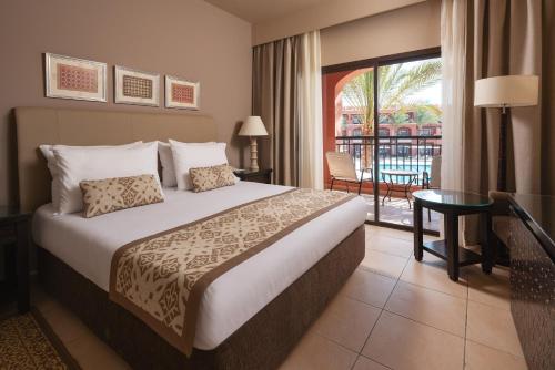 a hotel room with a bed and a balcony at Jaz Tamerina, Almaza Bay in Marsa Matruh