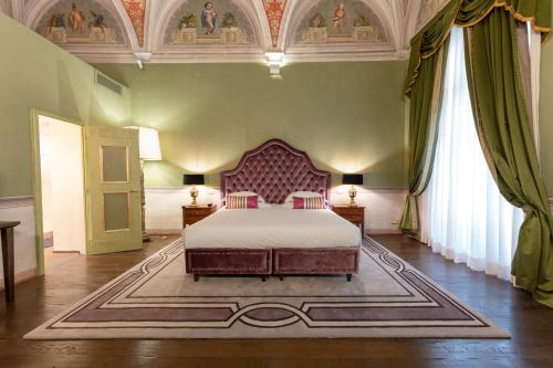a bedroom with a large bed in a green room at Grand Hotel Cavour in Florence