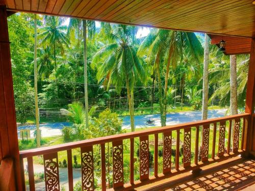 a balcony with a view of a palm tree forest at Family Resort in Ban Tai