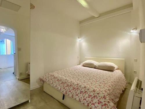 une chambre avec un lit avec deux oreillers dessus dans l'établissement Vieux-Nice 2 pièces proche mer, à Nice