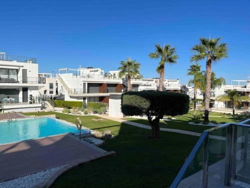 a view of a resort with a swimming pool and palm trees at Appartement Punta Prima in Torrevieja