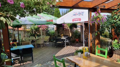 a patio with tables and chairs and an umbrella at Tawerna Rataje Pokoje Gościnne in Chodzież