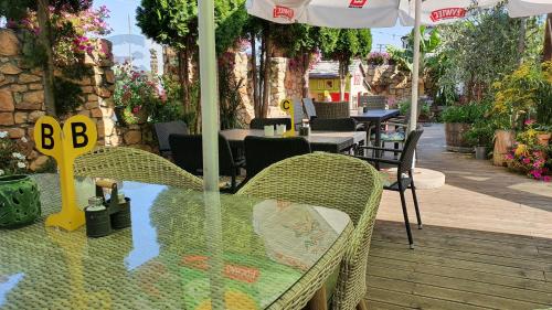 a table with chairs and an umbrella on a patio at Tawerna Rataje Pokoje Gościnne in Chodzież