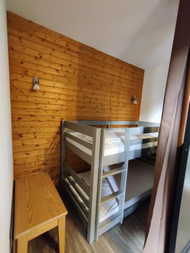 a room with a bunk bed and a wooden wall at Orelle 3 Vallées - Studio 4 personnes in Orelle