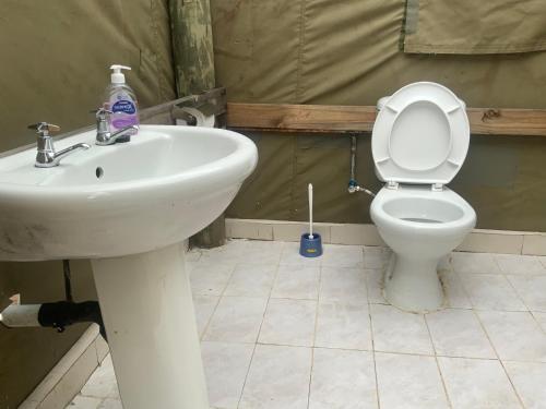 a bathroom with a white sink and a toilet at Lorato Lodge and Camping in Muchenje