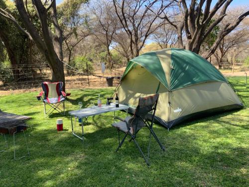 a tent and a table and chairs in a field at Lorato Camping in Muchenje