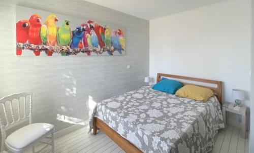 a bedroom with a bed and a painting of parrots at Joli appartement face au port, accès direct plage 4RP17 in Le Barcarès