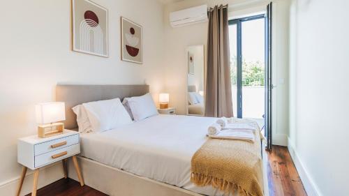 a white bedroom with a bed and a window at Terrace Pool Apartment Oporto by LovelyStay in Porto