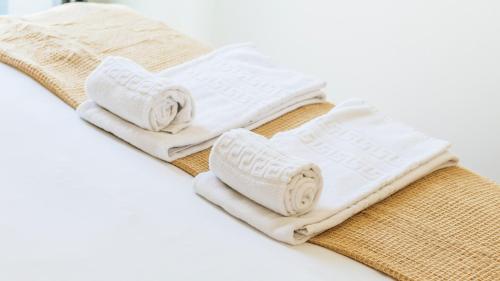 a pile of towels sitting on top of a bed at Terrace Pool Apartment Oporto by LovelyStay in Porto