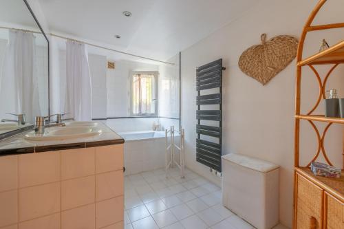 uma casa de banho com um lavatório e uma banheira em La Célestine - Belle maison en pierre de 250m2 avec jardin em Mudaison