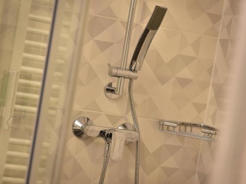 a shower with a hose in a bathroom at Ramada Airport Hotel Prague in Prague