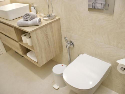 a bathroom with a white toilet and a sink at Duque Beachside Elegance in Adeje