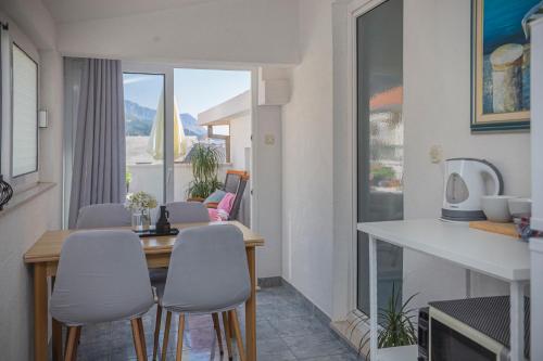 uma sala de estar com uma mesa e cadeiras e uma janela em Apartmani Leo-Marin em Makarska
