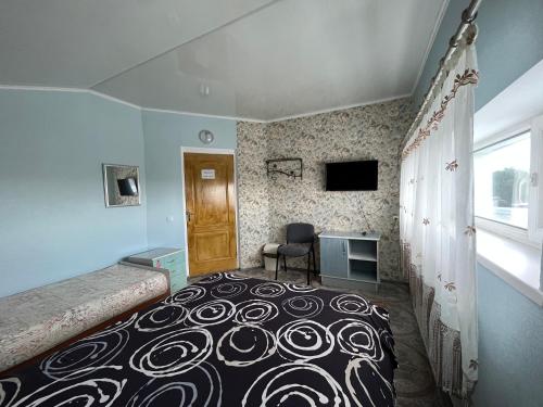 a bedroom with a bed and a desk and a window at Хостел Автоскло in Khmelnytskyi