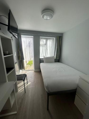 a bedroom with a white bed and a window at 3 ST JOHN'S CLOSE in London
