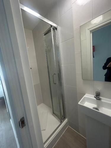 a bathroom with a shower and a sink and a mirror at 3 ST JOHN'S CLOSE in London