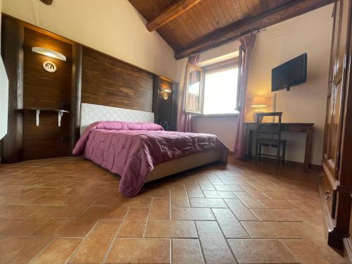 a bedroom with a bed and a table and a window at Appartamento Vacanze Il Daino in Leonessa