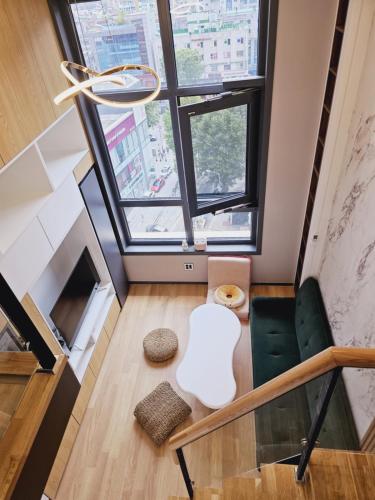 a living room with a green chair and a window at Luxury Apartment near Lotte World in Seoul