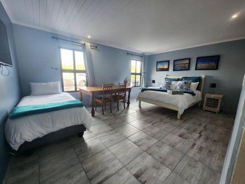 a bedroom with two beds and a dining room with a table at Hook Wine And Sinker in Langebaan