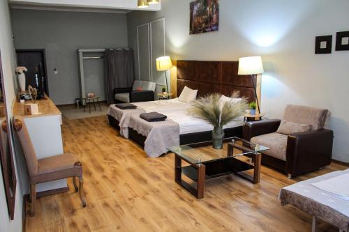 a bedroom with a bed and a couch and a table at R34 Boutique Guest House in Veliko Tŭrnovo