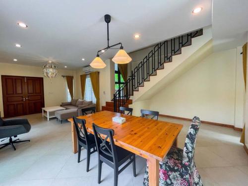 - une salle à manger avec une table et des chaises en bois dans l'établissement Black Pearl Villa Wongamat, à Pattaya (nord)