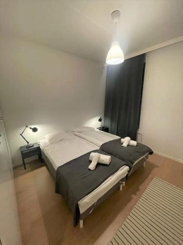a bedroom with a large bed with two towels on it at Kotimaailma - Saunallinen kolmio Herttoniemessä in Helsinki