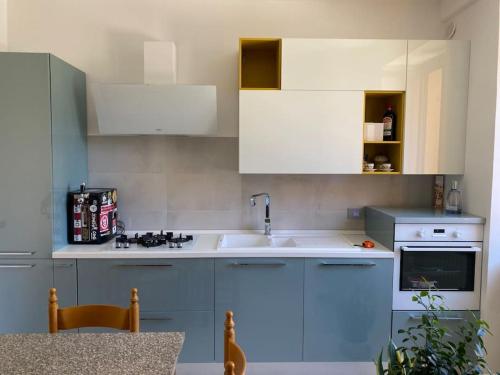 - une cuisine avec des placards bleus et blancs et un évier dans l'établissement B&B La vecchia fornace, à Teramo