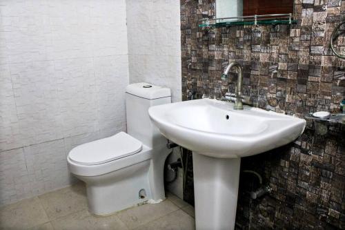 a bathroom with a white toilet and a sink at Atithi Stay By Kasa Lusso - Luxury 3 BHK In Faridabad in Faridabad