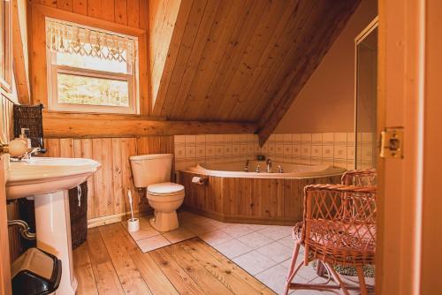 a bathroom with a tub and a toilet and a sink at Domaine Valga in Saint-Gabriel