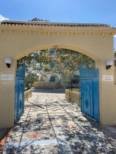 un arco con porte blu su un edificio di Dar El Ferdaous a Zarzis