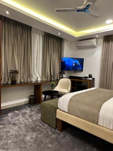 班加羅爾的住宿－ROYAL ACE LUXUR，一间卧室配有一张床、一张书桌和一台电视。