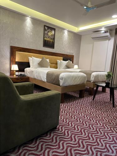 a hotel room with a bed and two chairs at ROYAL ACE LUXUR in Bengaluru