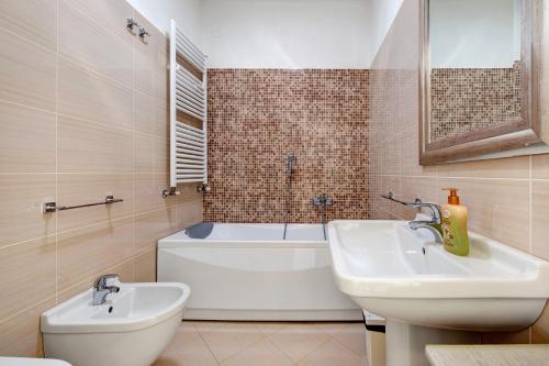 ein Badezimmer mit einem Waschbecken, einer Badewanne und einem WC in der Unterkunft Gran Fausto Trilo in San Felice del Benaco
