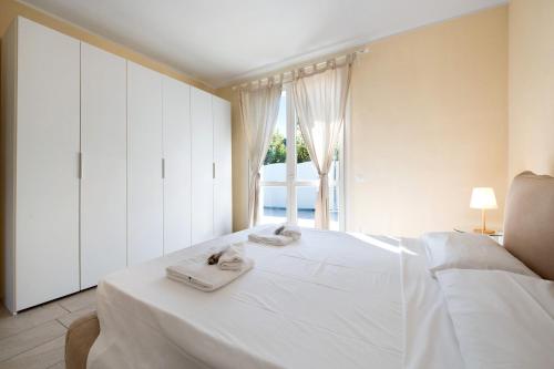 ein Schlafzimmer mit einem weißen Bett und Handtüchern darauf in der Unterkunft Gran Fausto Trilo in San Felice del Benaco