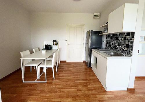 a kitchen with a table and chairs and a kitchen with white cabinets at The Trust condo 2 bed room Hua hin in Hua Hin