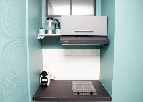 eine Küche mit einem Herd und einem Laptop auf einer Theke in der Unterkunft Studio tout équipé centre-Ville proche de la gare in Cluses