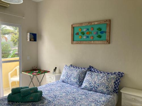 - une chambre avec un lit et une peinture murale dans l'établissement Suítes Amigos do Pescador, à Parati