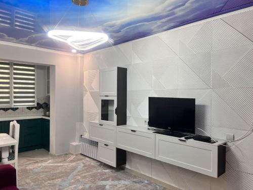 ein Wohnzimmer mit einem Flachbildfernseher an der Wand in der Unterkunft 2-х комнатная квартира на Арбате in Almaty