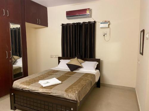 a small bedroom with a bed with black curtains at The Pearl 1Bhk / 2Bhk in Chennai