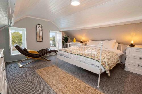 una camera con un letto bianco e una sedia di Traditional Cottage with Private Hot Tub in the Heart of Donegal a Letterkenny
