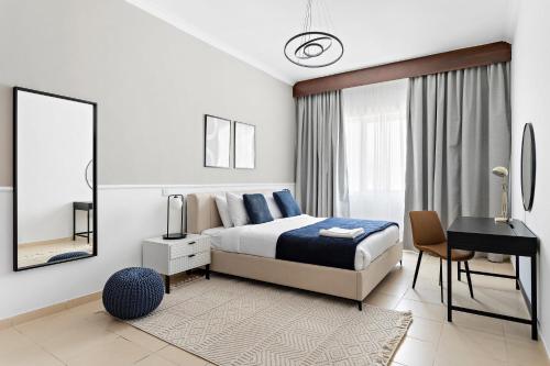 una camera con letto, scrivania e specchio di Silkhaus Modern Living Studio in Art Residence a Dubai